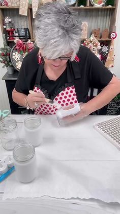 an older woman is working on some crafting supplies