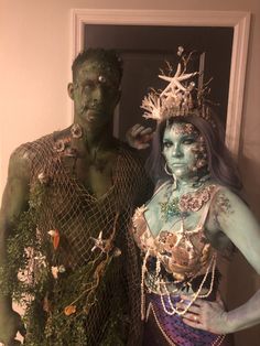 two people dressed up as zombies and mermaids pose for a photo in front of a mirror