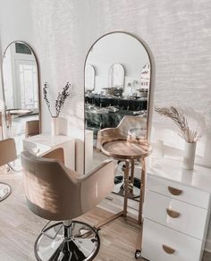 a salon with mirrors, stools and chairs in the middle of it's room