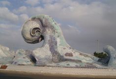 an artistic sculpture in front of a cloudy sky