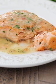 a white plate topped with fish covered in gravy