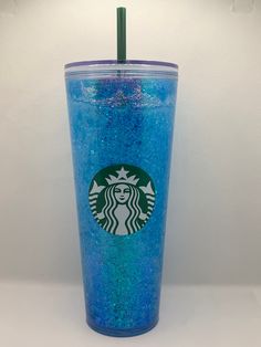 a blue starbucks cup with a green straw