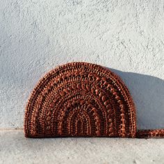 a brown purse sitting on top of a white wall