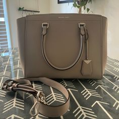 Michael Kors Benning Satchel In Pearl Grey. Smooth Leather. Two Side Zipper Compartments, Zipper Pocket And Open Pocket Inside. Comes With Shoulder Strap. Excellent Usd Condition, Though Please Note Very Small Spot On Front Edge (Pictured). Can Probably Be Cleaned. Approximately 13 X 10 X 5.5. If You Would Like Additional Pictures Please Ask! All Listings Come From A Pet-Loving Home! Questions? Leave A Comment Below! Classic Michael Kors Satchel With Handles, Elegant Michael Kors Rectangular Satchel, Bags Michael Kors, Pearl Grey, Grey Color, Smooth Leather, Size 13, Inside Pocket, Side Zipper