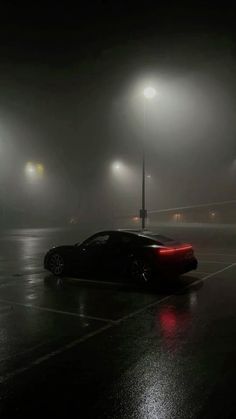 a car parked in a parking lot on a foggy night