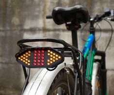 a close up of a bike with a red light on the handlebars and back tire