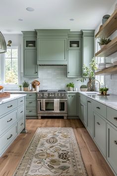 a kitchen with green cabinets and an area rug on the floor in front of the stove