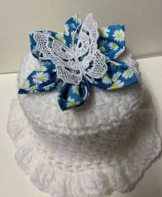 a white crocheted hat with blue and yellow flowers