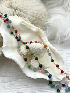 Are you looking for a unique way to add a splash of color to your jewelry designs? Our Colorful Stone Beaded Rosary Chains are the perfect way to do just that! Each chain is made with 4.5mm stone beads on gold wire and comes in 4 different styles. Style #1 features mixed green stone beads, style #2 features green, pink, and blue stone beads, style #3 features pink, red, orange, green, and blue stone beads, and style #4 features light blue stone beads. Each chain is sold by the foot, so you can g Multicolor Wire Wrapped Beaded Necklaces, Wire Wrapped Round Beads For Jewelry Making, Multicolor Beaded Chain With Round Beads, Multicolor Round Beaded Chain Beads, Multicolor Beaded Chain, Hand Knotted Pearls, Beaded Rosary, Beads Style, Rosary Chain