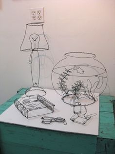 a fish bowl, lamp and other items on a table