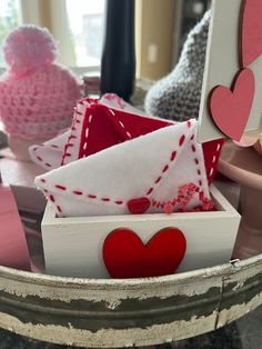 a white box filled with lots of red and pink hearts on top of a table