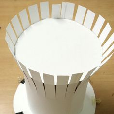 the paper is cut out and placed on top of the cake stand to look like it has been folded