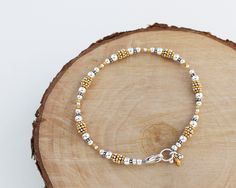 "This bracelet features a variety of sterling silver and gold vermeil beads strung in a flowing sequence of symmetry. Finished with a secure sterling silver lobster clasp and a cluster of coordinating charms. Perfect to wear by itself or layered with other bracelets for a stacked look. A classic piece that transitions seamlessly from day to night. Total length measures 7 5/8\". Sterling silver is .925 pure silver. Gold vermeil is 14k-24k gold plated sterling silver. See more mixed metal jewelry Gold Beaded Sterling Silver Bracelets, Gold Bracelet With Tiny Beads In Sterling Silver, Bracelet With Charms, Bali Silver, Mixed Metal Jewelry, Hill Tribe Silver, Silver Bead Bracelet, Leaf Jewelry, Sterling Silver Bead