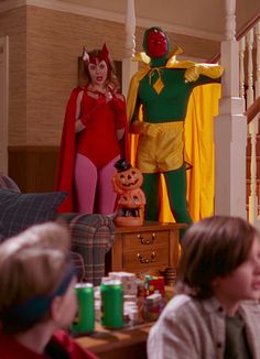 two people in costumes are sitting at a table and one person is standing behind them