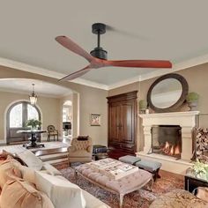 a living room with couches, chairs and a ceiling fan in the middle of it