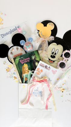 the contents of a mickey mouse birthday gift bag are laid out on a white surface