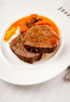 a white plate topped with meat and vegetables