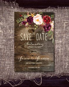 rustic save the date card with flowers on wood and burluck fabric is displayed