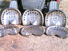 four pieces of metal sitting next to each other on the ground near a motorbike