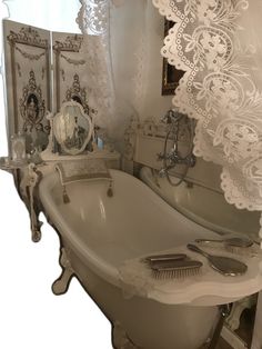 an old fashioned claw foot bathtub in front of two mirrors with lace on them