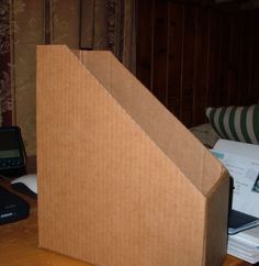 an open cardboard box sitting on top of a wooden table next to a laptop computer