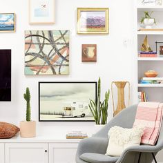 a living room filled with furniture and pictures on the wall next to a flat screen tv