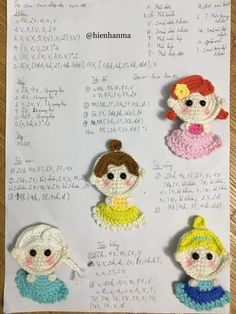 four crocheted dolls sitting on top of a piece of paper