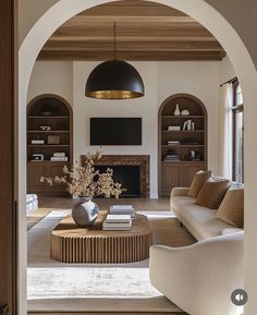 a living room filled with furniture and a fire place next to a doorway that leads to a sitting area