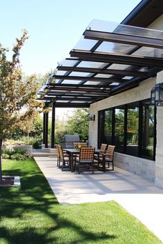 Modern outdoor patio with a glass pergola, dining table set, and a grill. Patio Cover Retractable, Patio Retractable Shade, Retractable Glass Roof Patio, Retractable Pergola Canopy Waterproof, Metal Pergola With Retractable Canopy, Diy Patio Cover