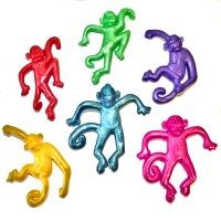 six small plastic monkeys in different colors on a white surface with one sitting down and the other standing up