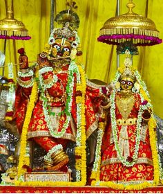 the statue is decorated with flowers and other decorations on it's sides, along with two bells