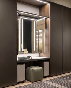 a bathroom with a vanity, mirror and stool next to it in front of a closet