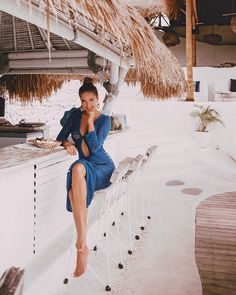 a woman in a blue dress sitting on a bench