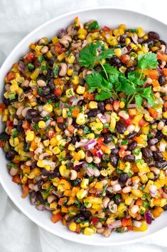 a white bowl filled with black - eyed corn and garnished with cilantro