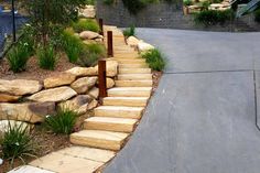 a set of stone steps leading up to a fenced in area with grass and rocks