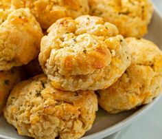 a white plate topped with biscuits covered in cheese