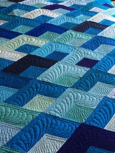 a blue and green quilt on a bed