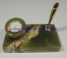 a marble desk with a pen and clock on it's stand in front of a white background