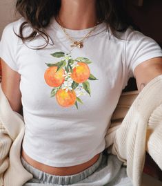 Transport yourself to a groovy era with our Vintage Orange Baby Tee--a vibrant ode to retro style and fruity fun. Crafted with a nod to y2k fashion, this graphic tee infuses your wardrobe with a burst of citrus charm. Featuring a playful vintage graphic, this fruit baby tee is more than just a shirt; it's a statement piece that effortlessly blends nostalgia with contemporary flair. Whether you're embracing the boho trend or adding a coquette touch to your ensemble, this tee is sure to turn heads Grandma Aesthetic, Fruit Shirt, Boho Trends, Orange Baby, 90s Fashion Outfits, Crop Top And Shorts