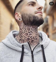 a man with a tattoo on his neck stares up into the sky while wearing a hoodie