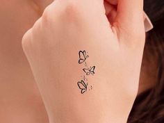 a woman with a tattoo on her left arm and butterfly tattoos on her right wrist