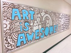 a sign that says art is awesome on the side of a wall in a school hallway