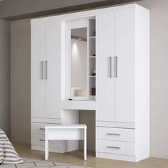 a bedroom with a bed, desk and white cupboards in front of the wall