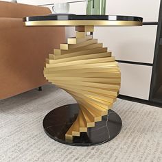 a table that has been designed to look like a spiral staircase in gold and black