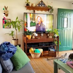 a living room filled with furniture and a flat screen tv on top of a wooden shelf