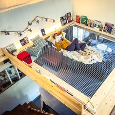 a woman laying on top of a bed in a room filled with pictures and books