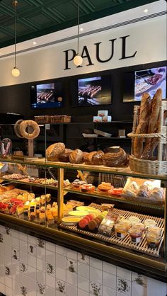 a bakery filled with lots of different types of breads and pastries on display