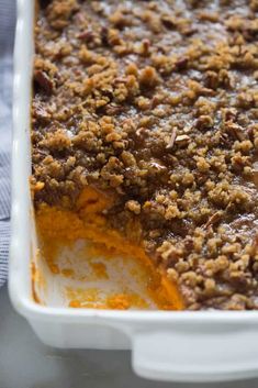 a casserole dish filled with sweet potato casserole and topped with crumbs