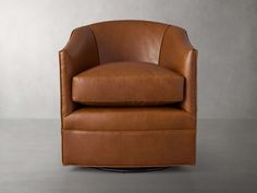 a brown leather chair sitting on top of a gray floor