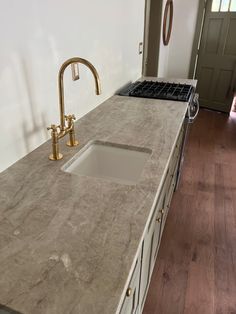 a kitchen counter top with a sink and faucet